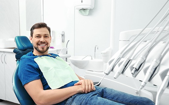 Man sitting in dental chair smiling and waiting for dentist