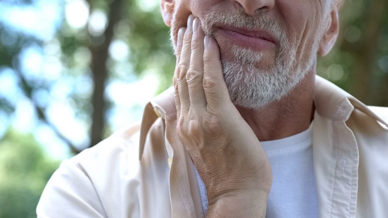 An older man experiencing some sensitivity in his dental implants